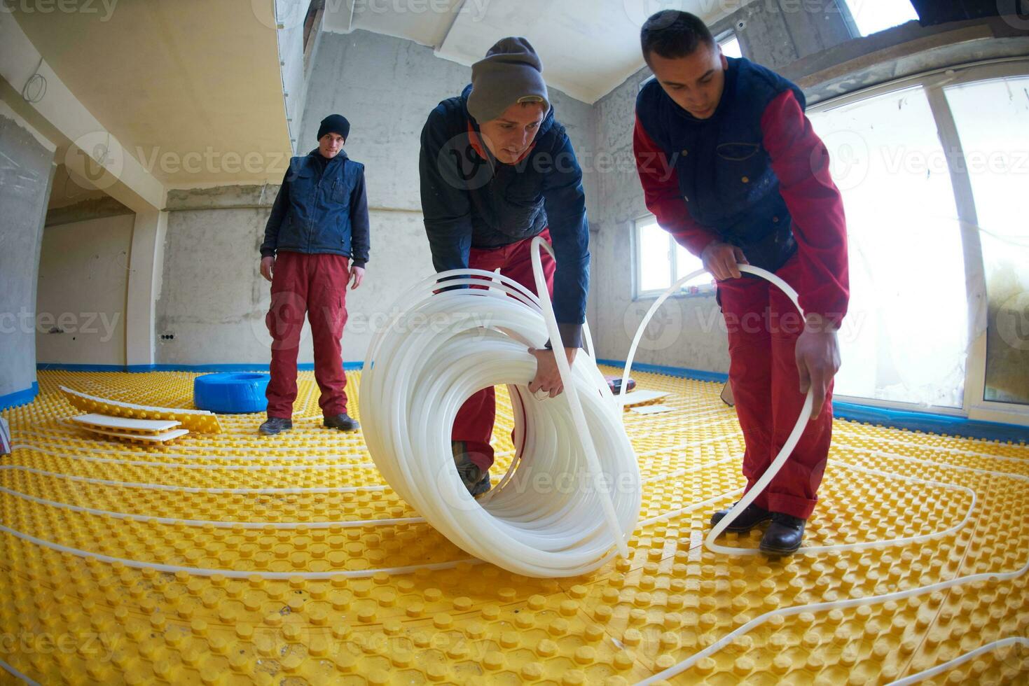 workers installing underfloor heating system photo