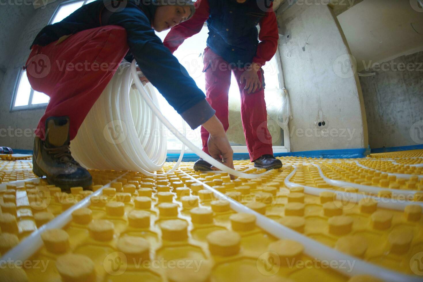workers installing underfloor heating system photo