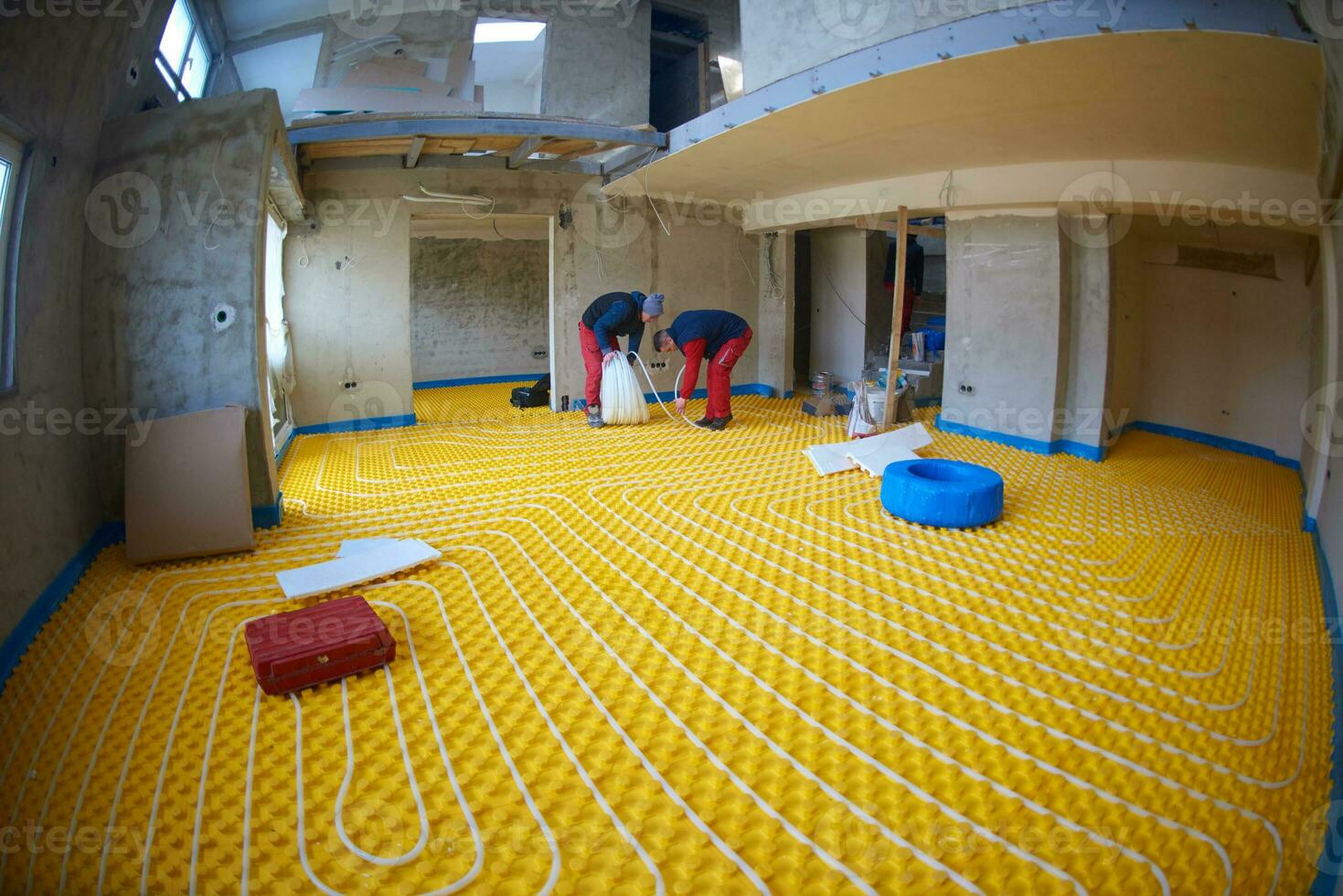 workers installing underfloor heating system photo