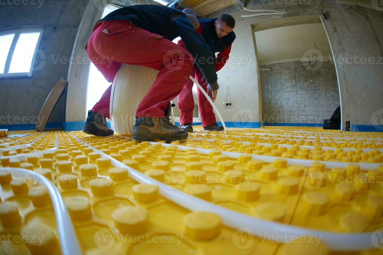 workers installing underfloor heating system photo