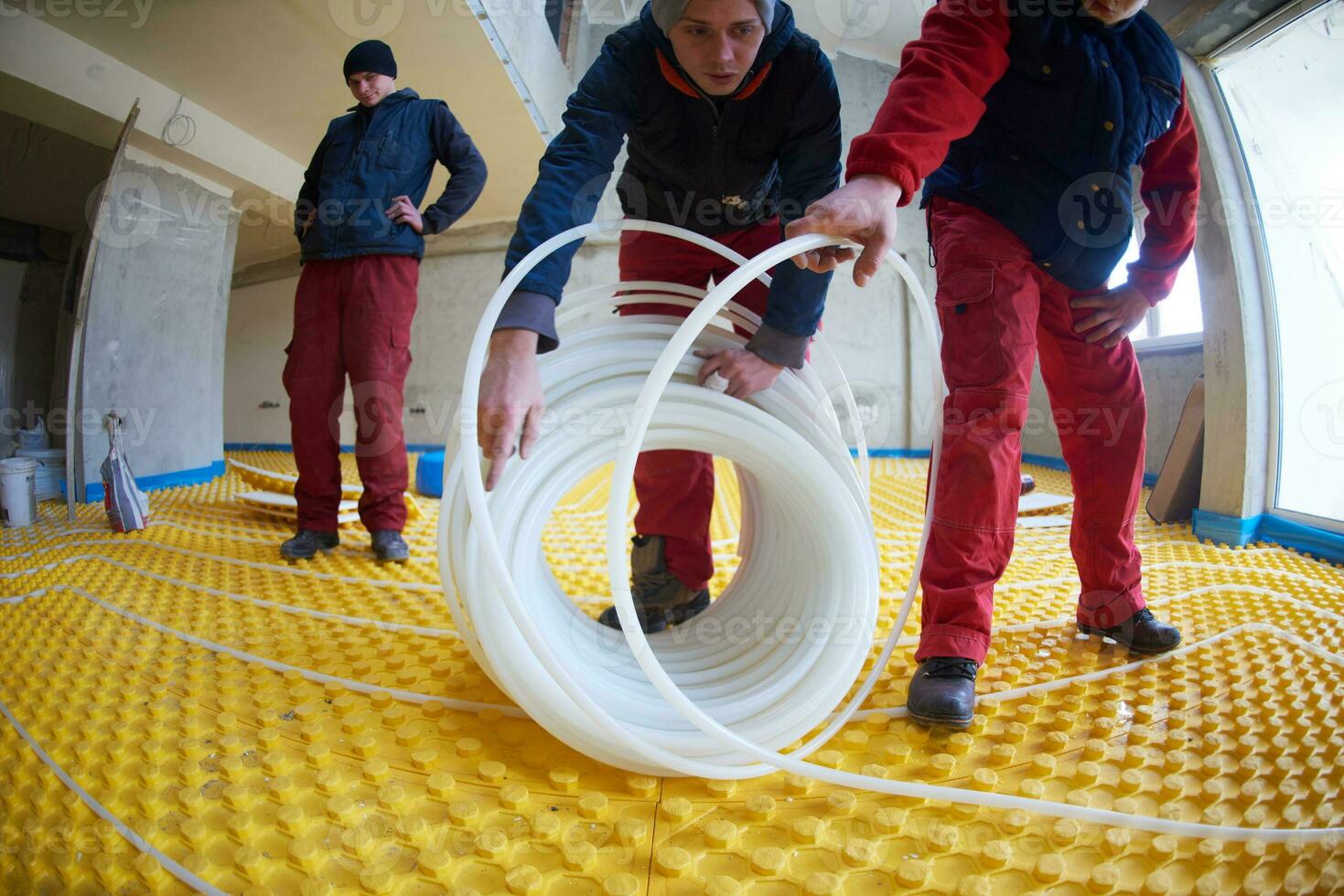 workers installing underfloor heating system photo
