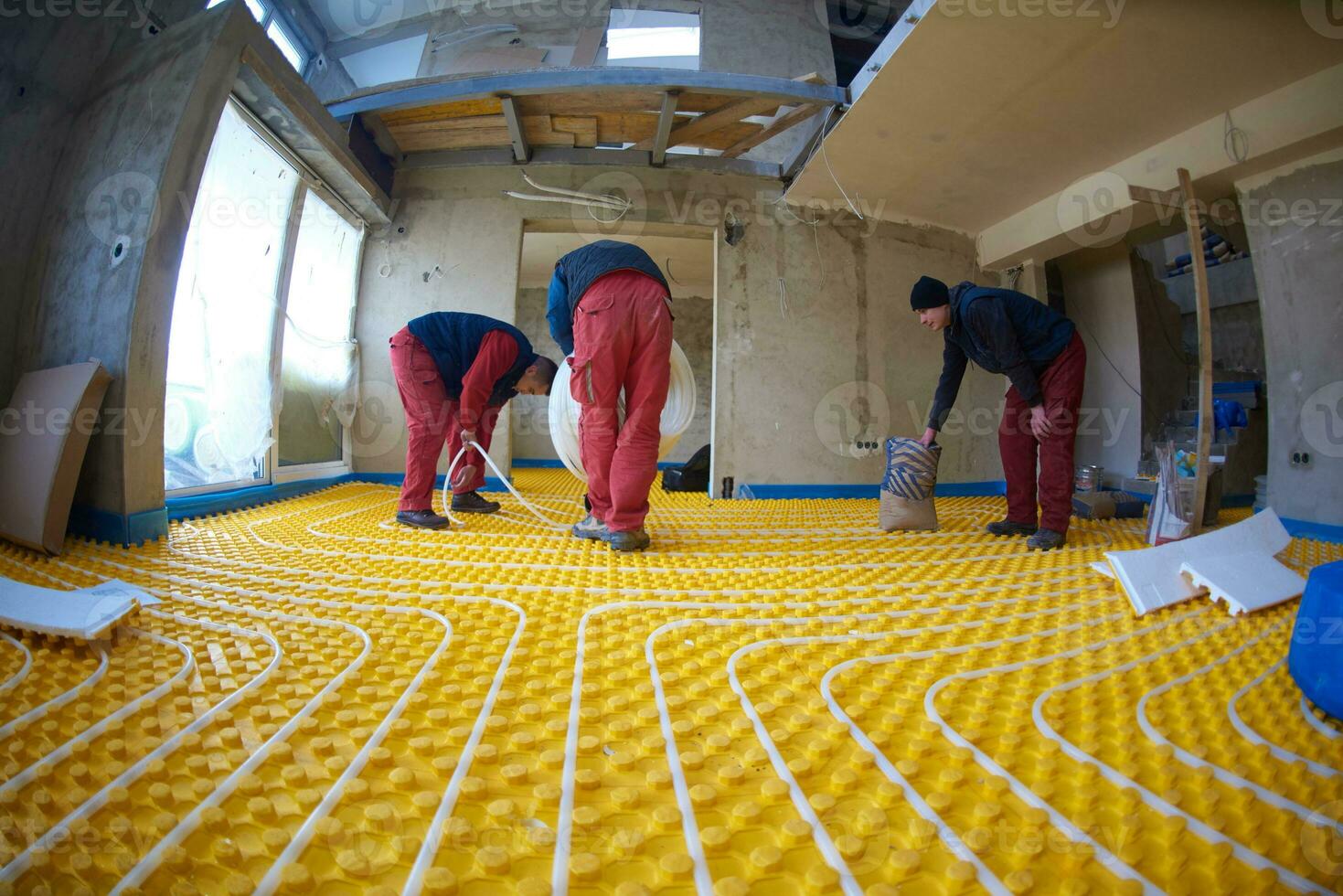 workers installing underfloor heating system photo