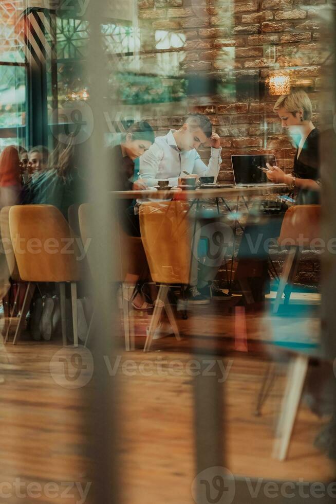 Happy businesspeople smiling cheerfully during a meeting in a coffee shop. Group of successful business professionals working as a team in a multicultural workplace. photo