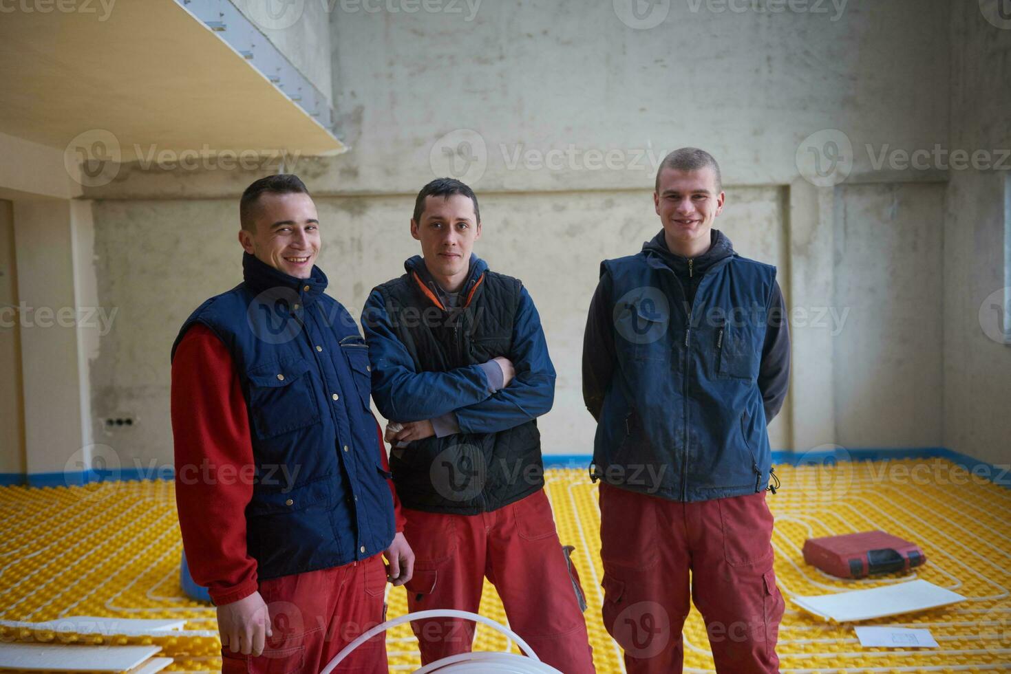 workers installing underfloor heating system photo