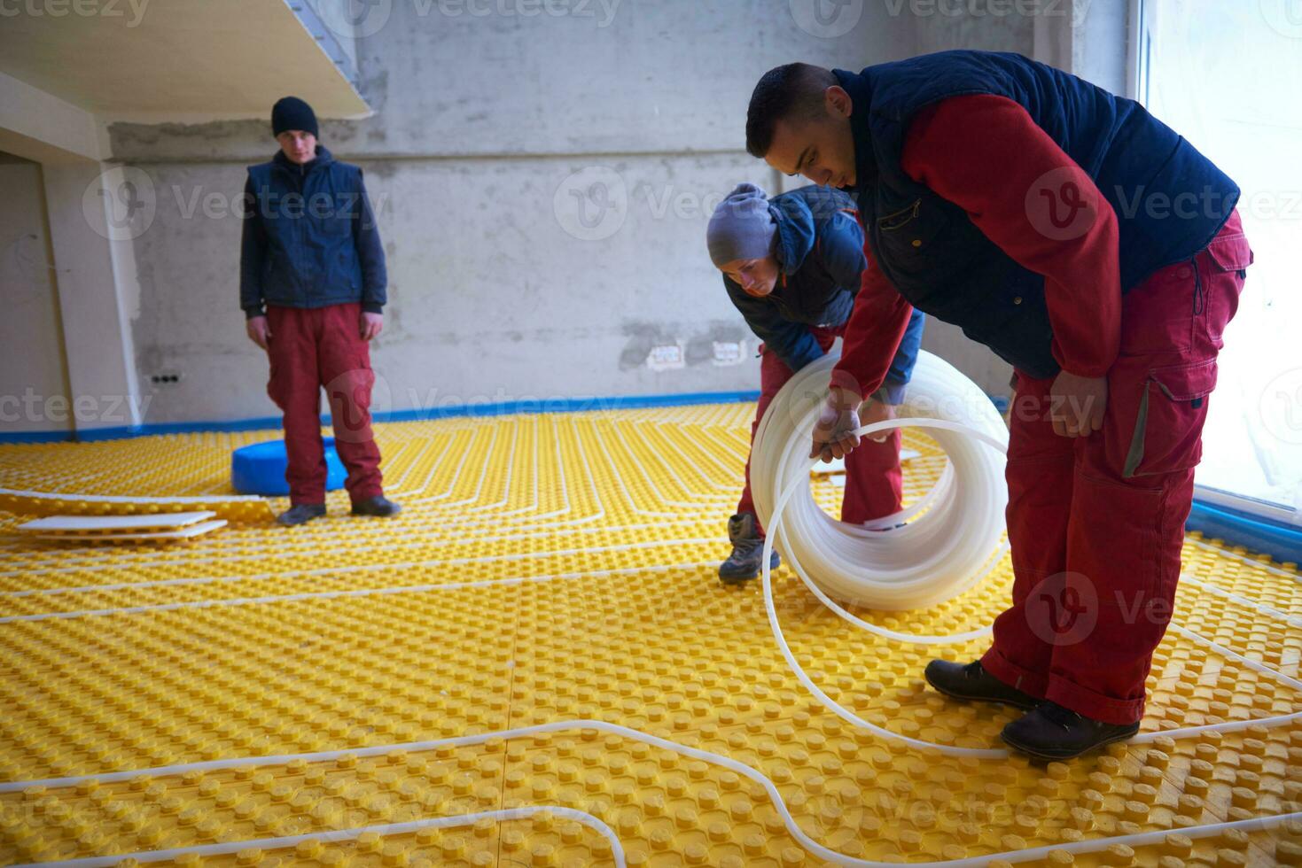 workers installing underfloor heating system 31057610 Stock Photo at