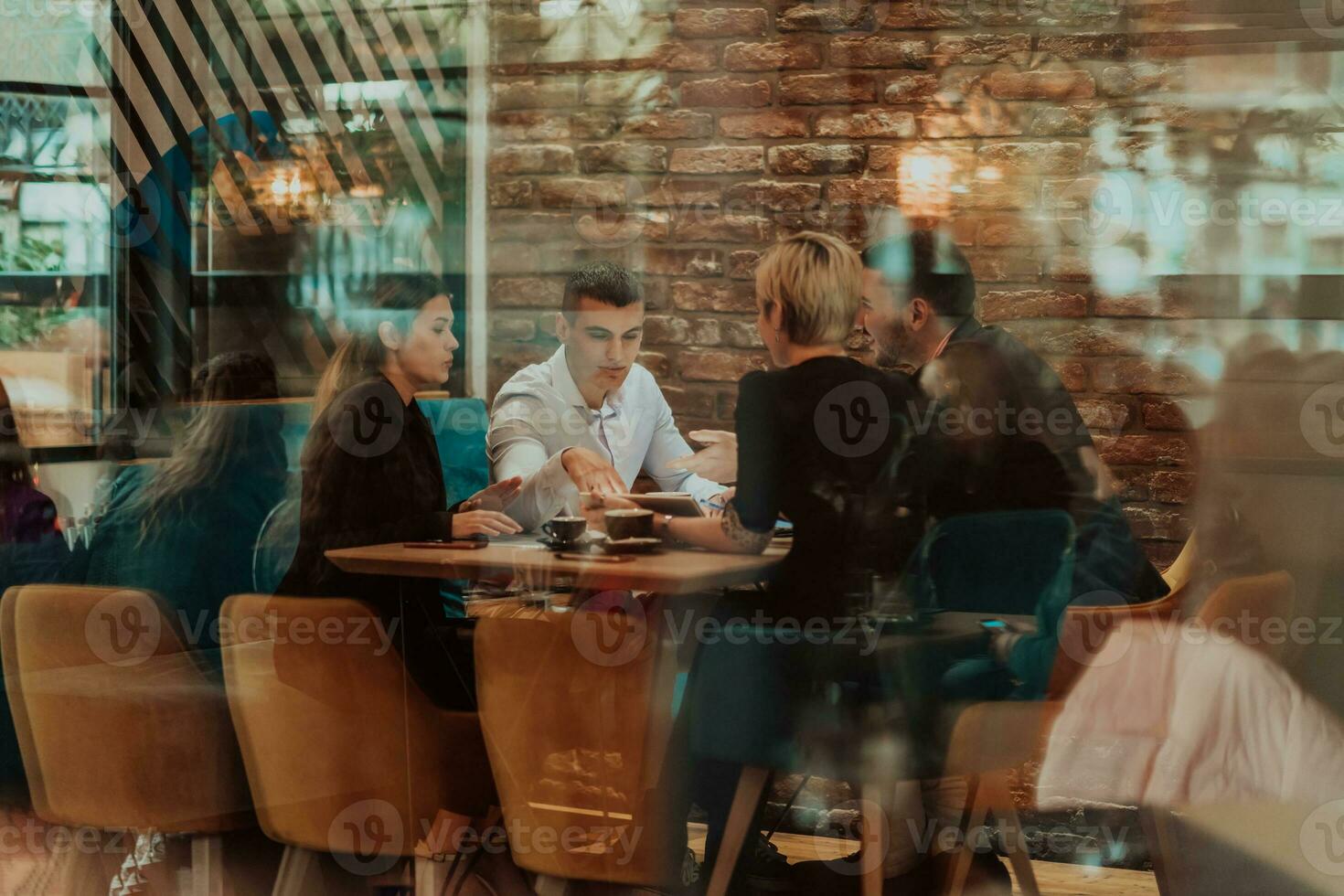 Happy businesspeople smiling cheerfully during a meeting in a coffee shop. Group of successful business professionals working as a team in a multicultural workplace. photo