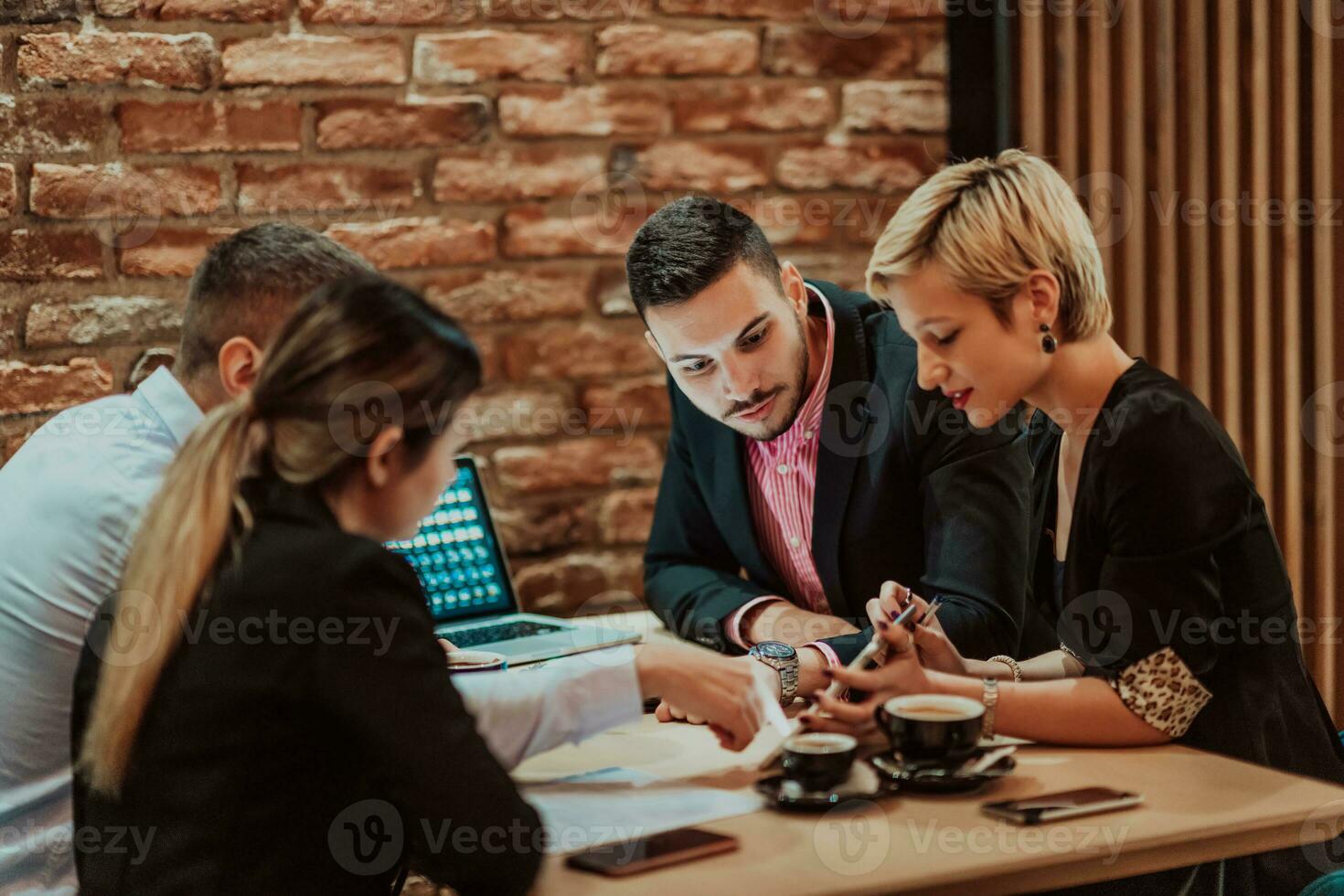 contento gente de negocios sonriente alegremente durante un reunión en un café tienda. grupo de exitoso negocio profesionales trabajando como un equipo en un multicultural lugar de trabajo. foto