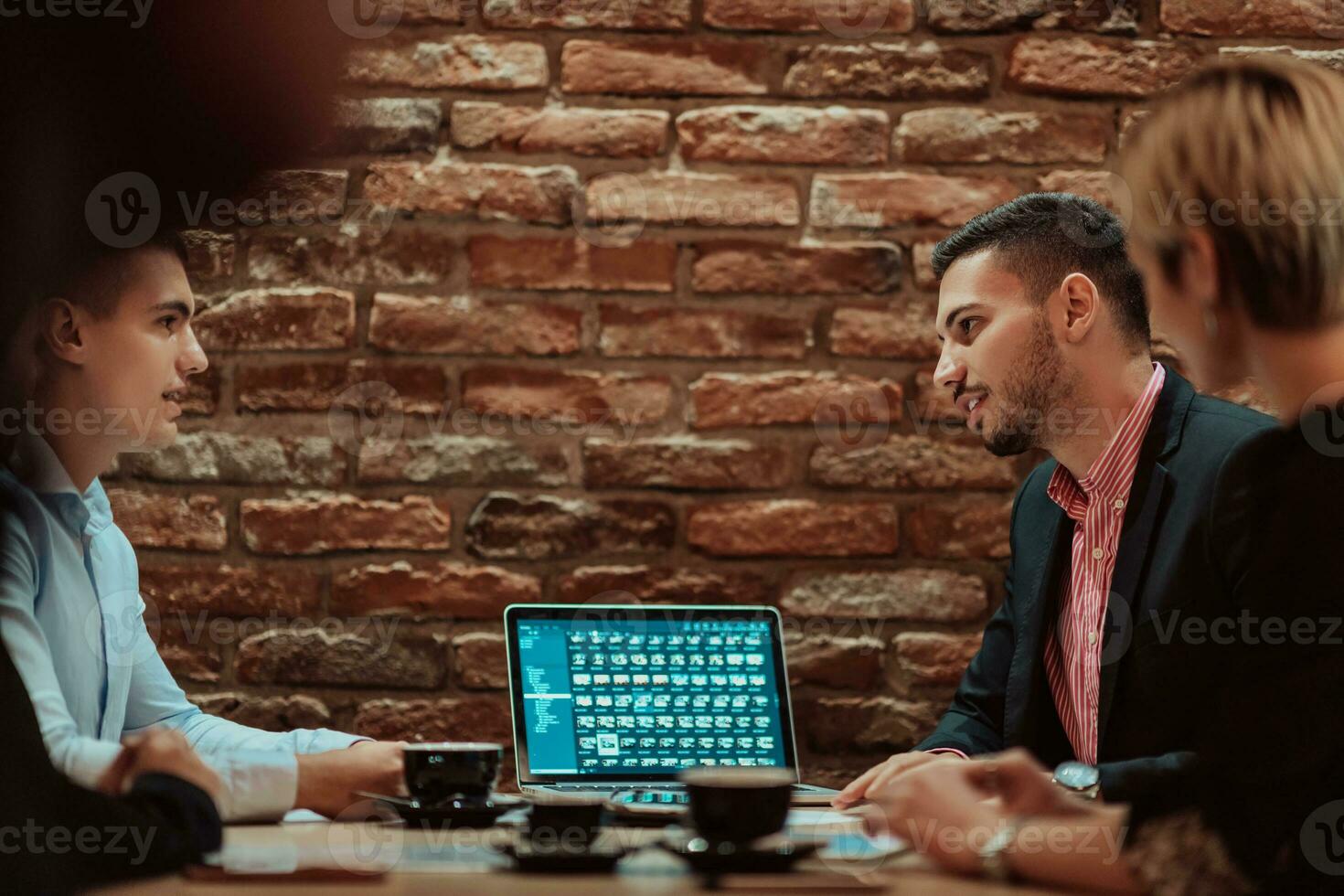 Happy businesspeople smiling cheerfully during a meeting in a coffee shop. Group of successful business professionals working as a team in a multicultural workplace. photo