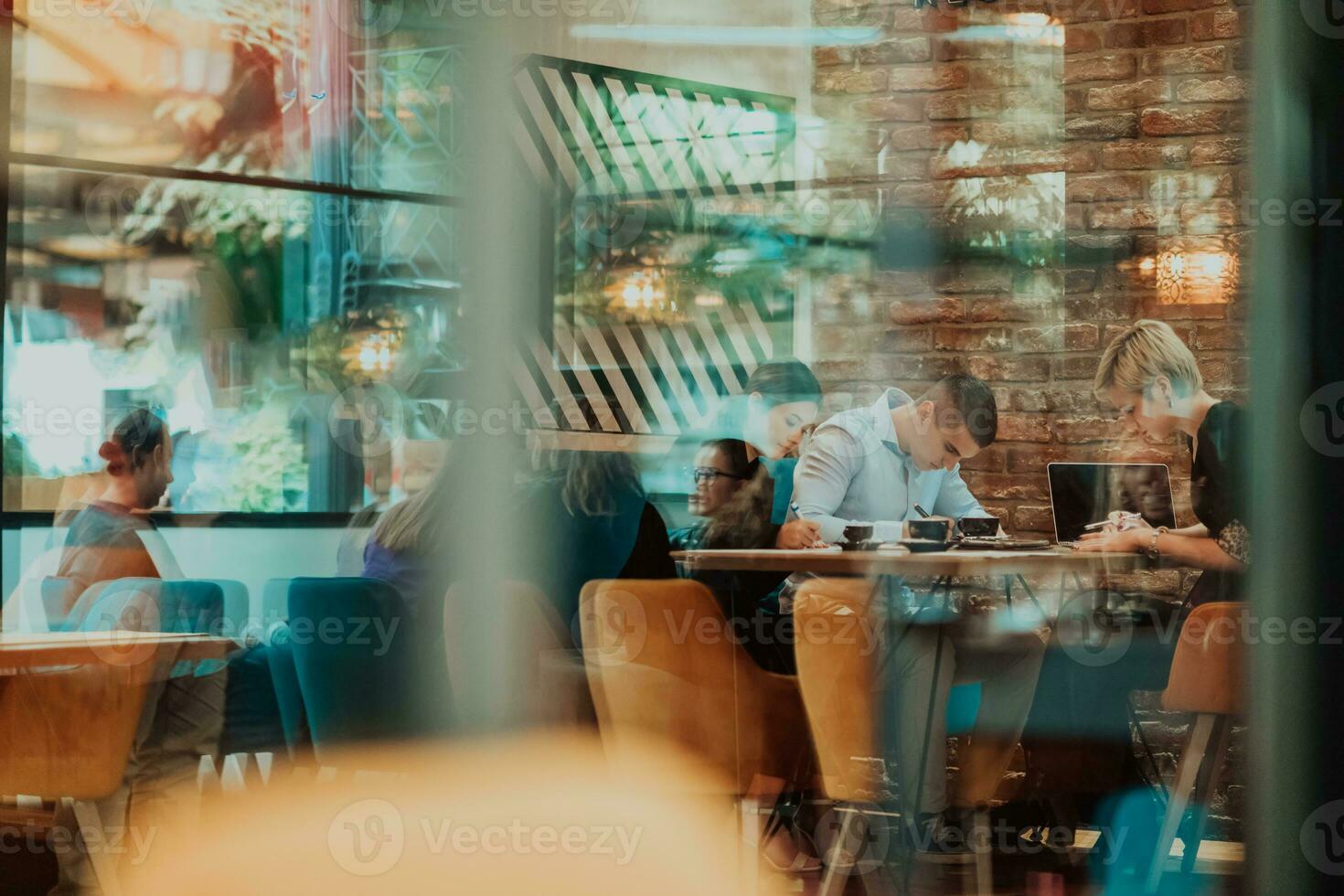 Happy businesspeople smiling cheerfully during a meeting in a coffee shop. Group of successful business professionals working as a team in a multicultural workplace. photo