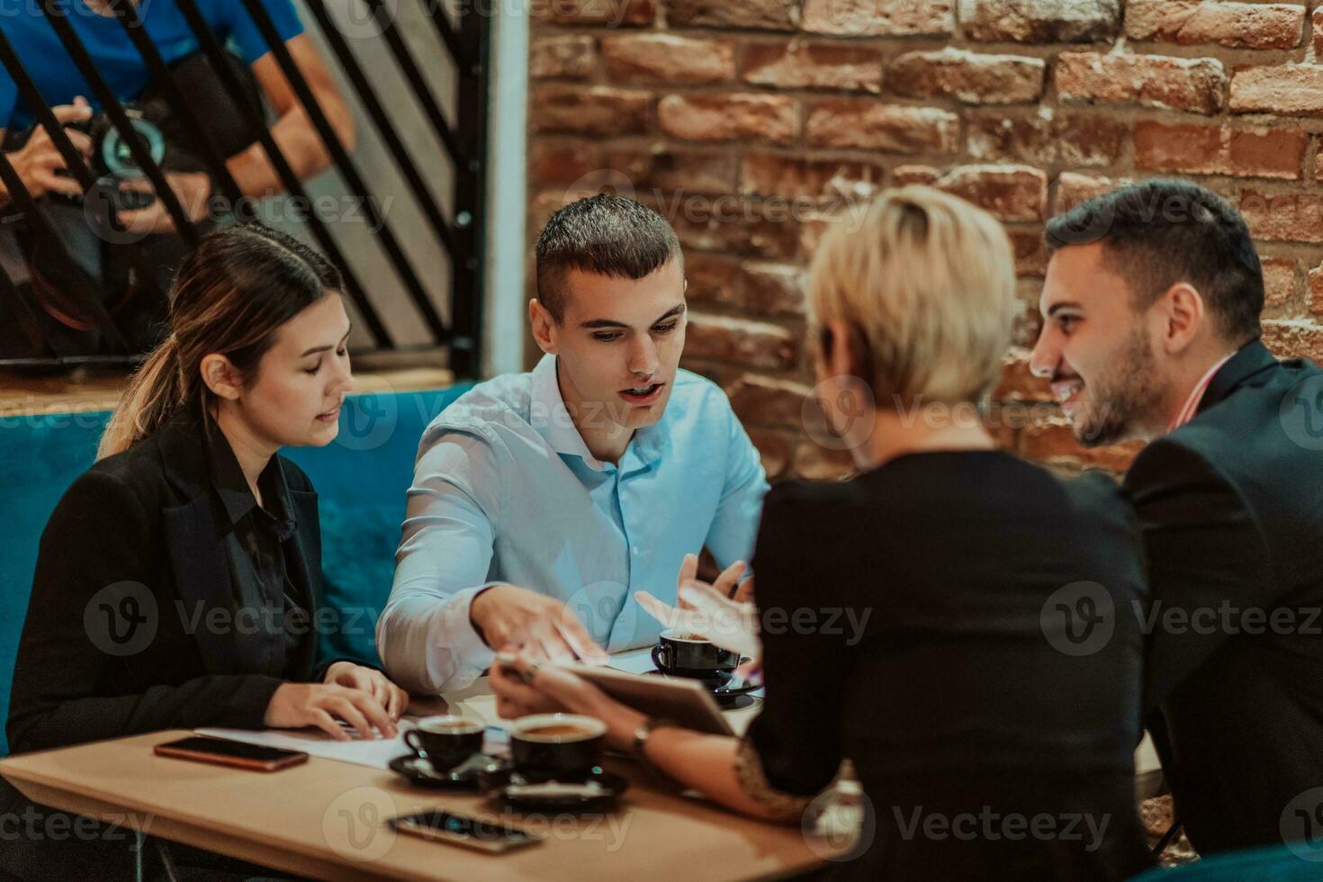 Happy businesspeople smiling cheerfully during a meeting in a coffee shop. Group of successful business professionals working as a team in a multicultural workplace. photo