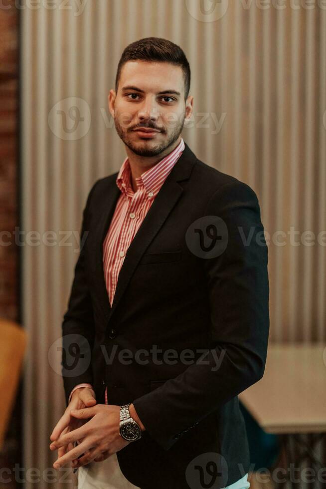 Portrait of a young businessman in a modern suit. Portrait of the company director in his office. Selective focus photo