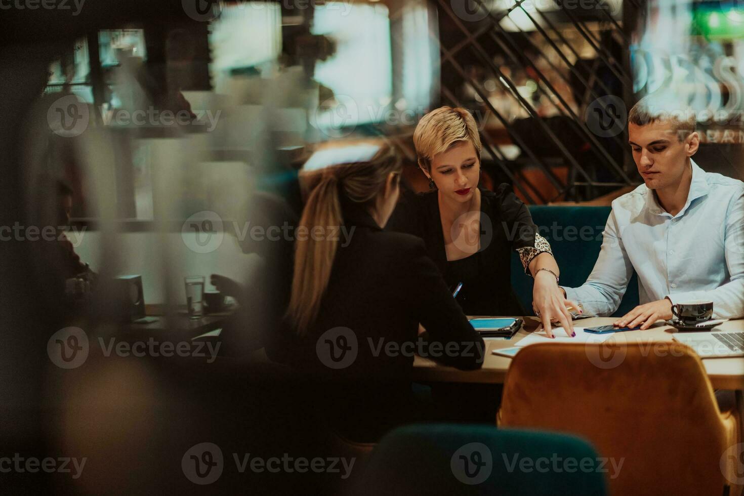 Happy businesspeople smiling cheerfully during a meeting in a coffee shop. Group of successful business professionals working as a team in a multicultural workplace. photo