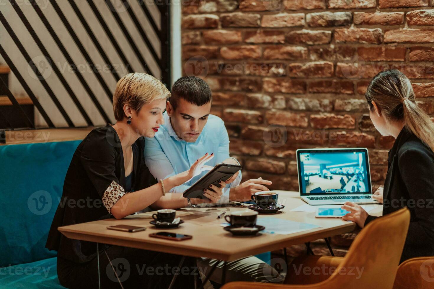 Happy businesspeople smiling cheerfully during a meeting in a coffee shop. Group of successful business professionals working as a team in a multicultural workplace. photo