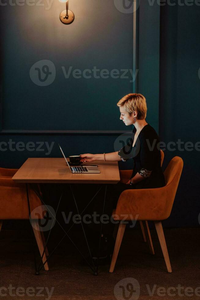 mujer de negocios sentado en un café mientras enfocado en trabajando en un ordenador portátil y participativo en un en línea reuniones selectivo enfocar. alto calidad foto
