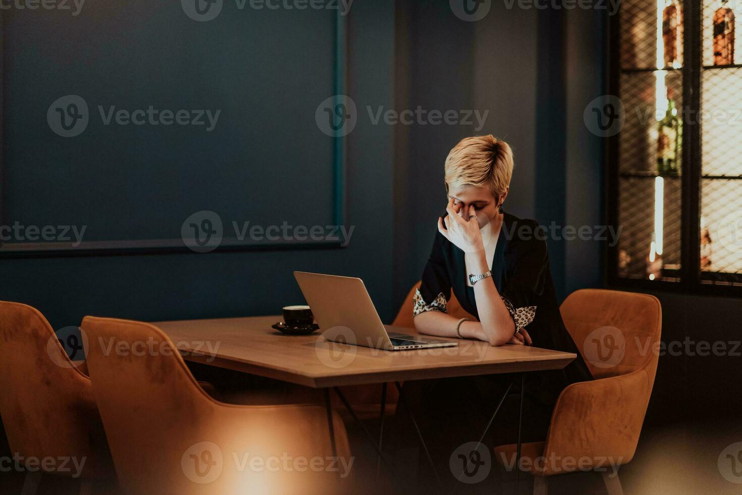 Businesswomen are stressed while working on laptop, Tired businesswoman with headache in coffee shop , feeling sick at work. Selective focus photo