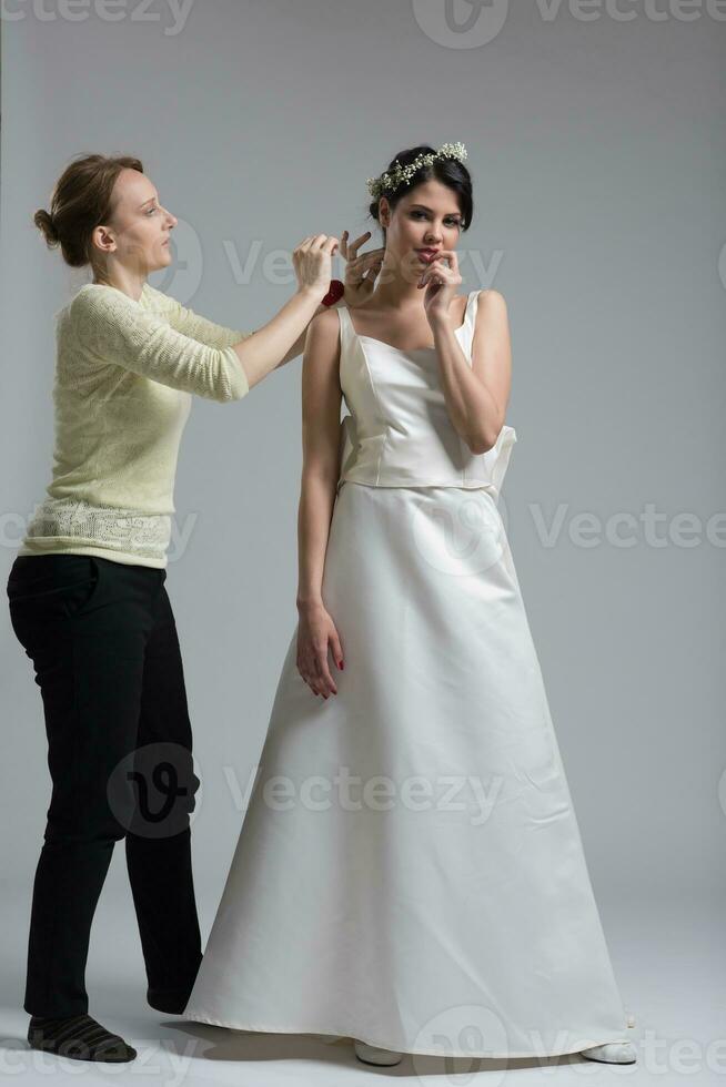 Beautiful young bride wears dress by stylist photo