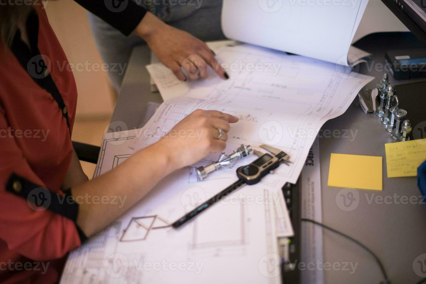 Engineer technician designing drawings mechanical parts engineering Enginemanufacturing factory Industry Industrial work project blueprints measuring bearings caliper tools photo