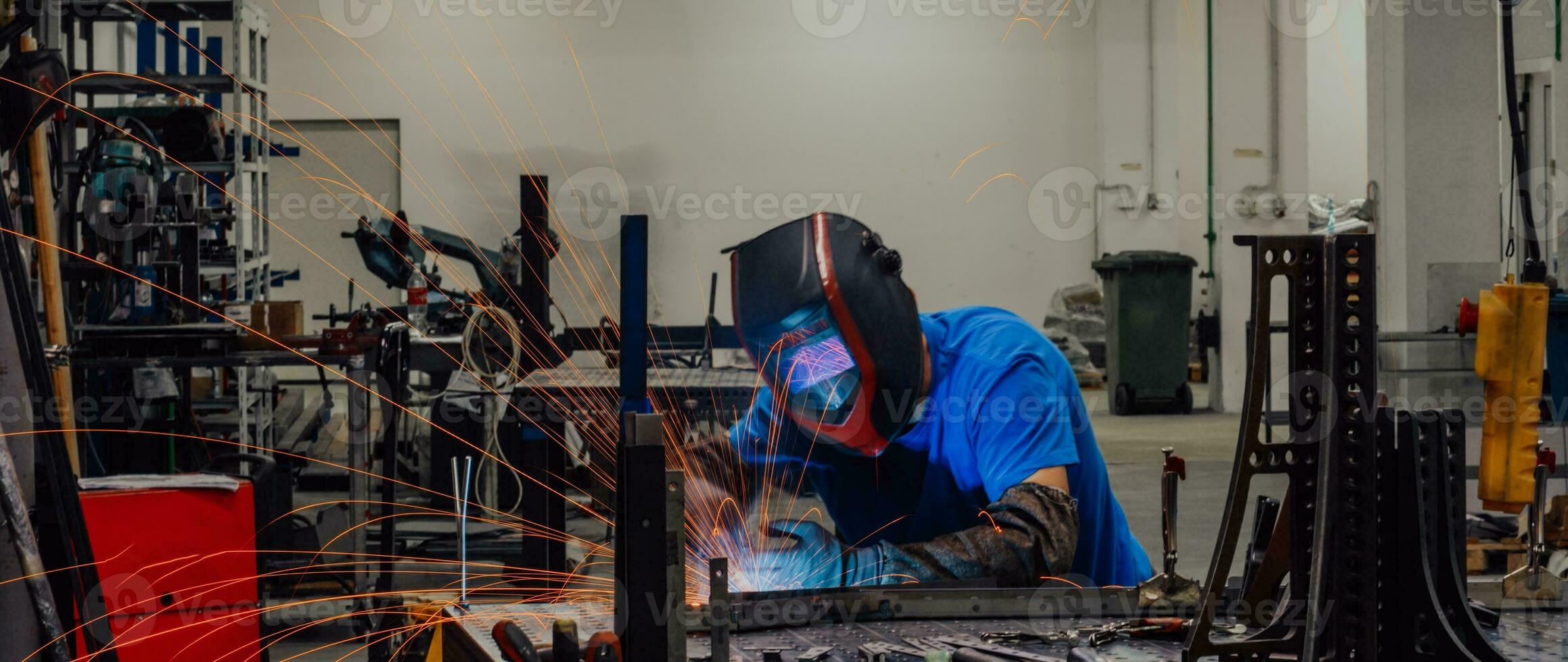 Professional Heavy Industry Welder Working Inside factory, Wears Helmet and Starts Welding. Selective Focus photo