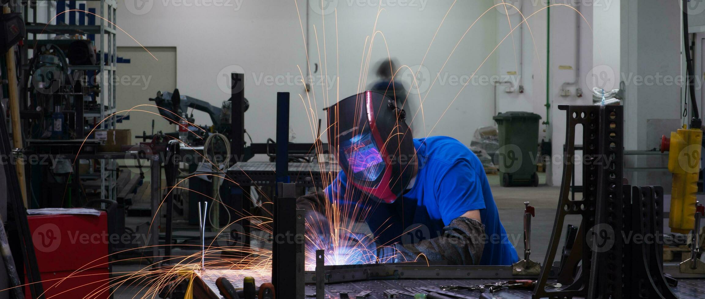 Professional Heavy Industry Welder Working Inside factory, Wears Helmet and Starts Welding. Selective Focus photo