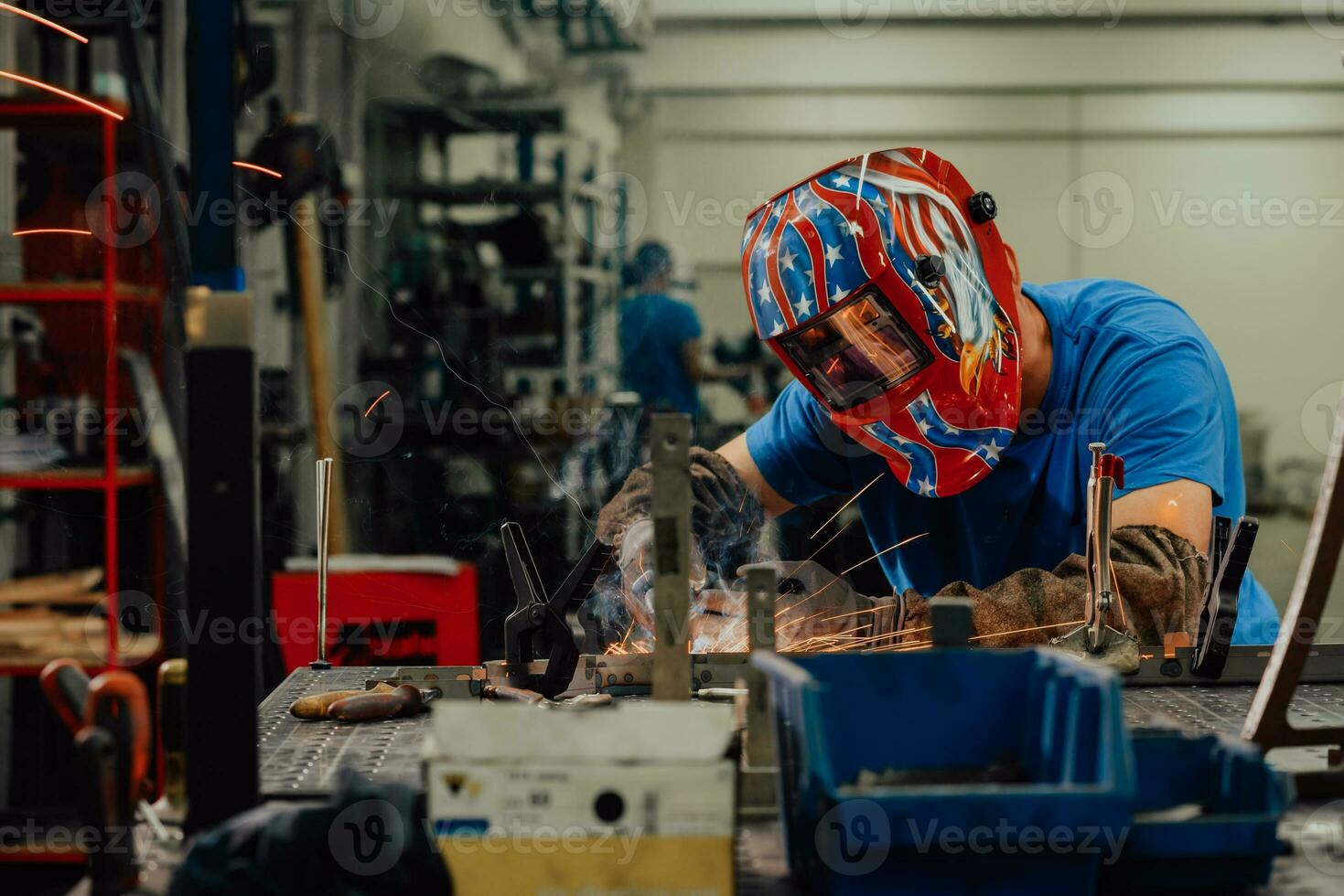 soldador profesional de la industria pesada que trabaja dentro de la fábrica, usa casco y comienza a soldar. enfoque selectivo foto