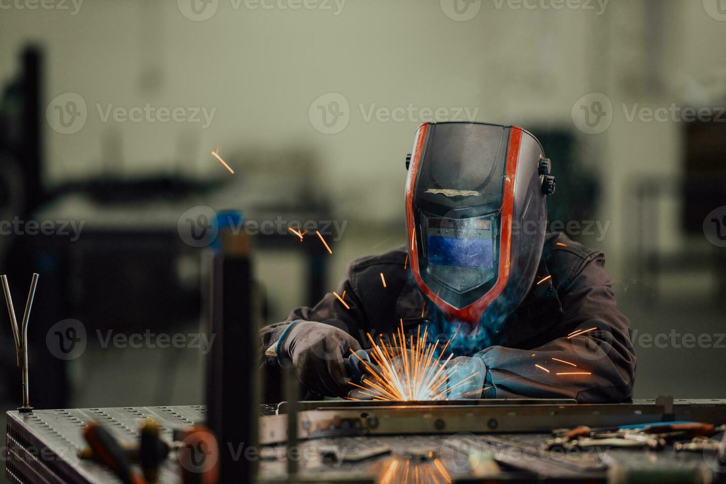 Professional Heavy Industry Welder Working Inside factory, Wears Helmet and Starts Welding. Selective Focus photo