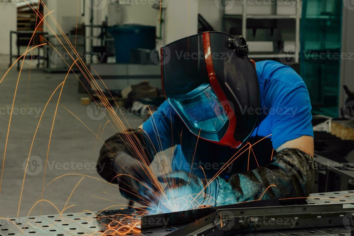 Professional Heavy Industry Welder Working Inside factory, Wears Helmet and Starts Welding. Selective Focus photo