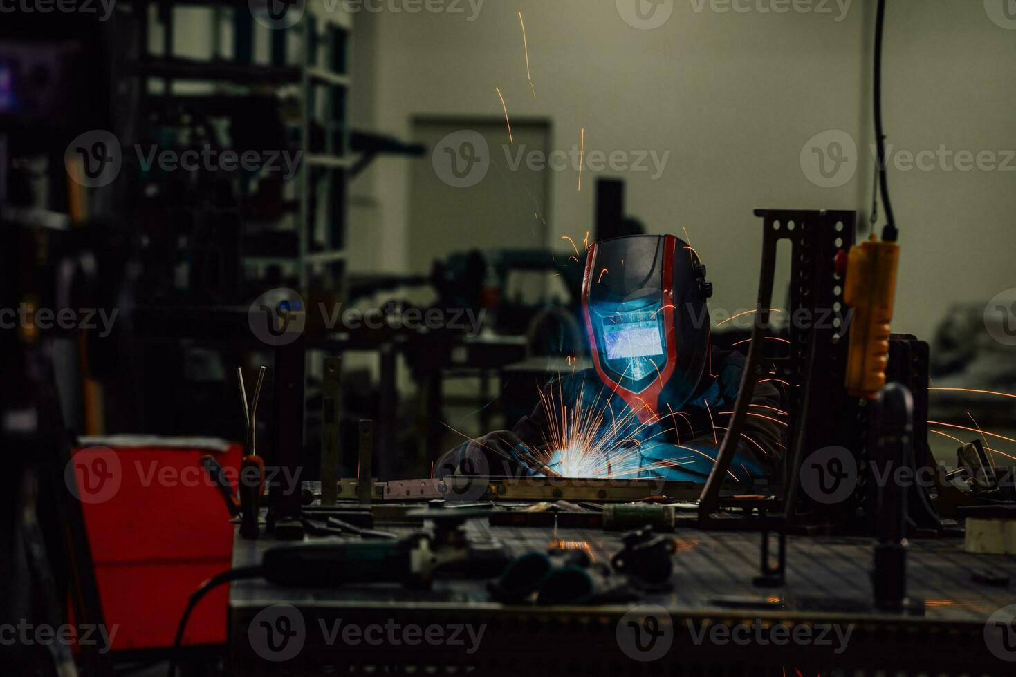 Professional Heavy Industry Welder Working Inside factory, Wears Helmet and Starts Welding. Selective Focus photo