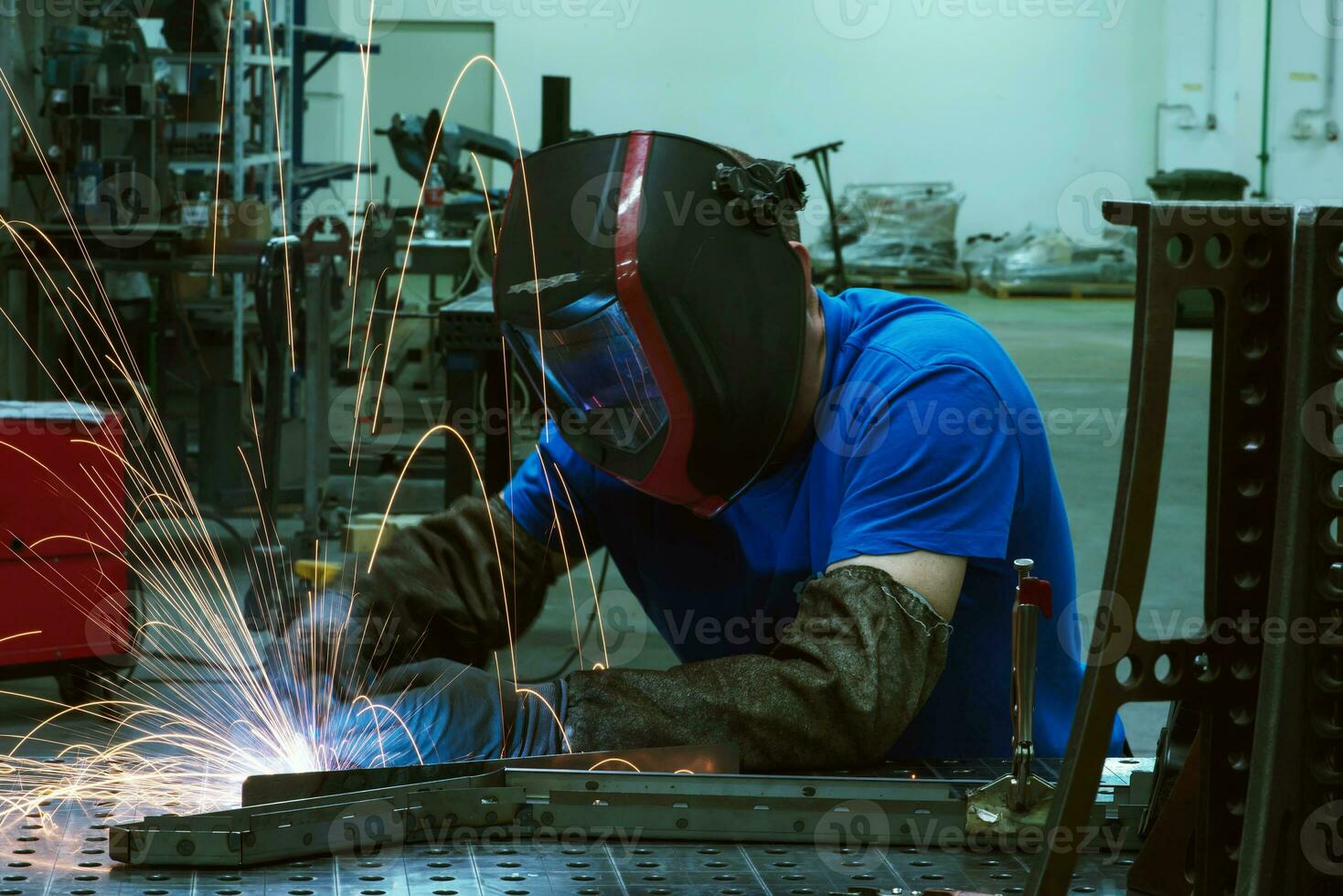 Professional Heavy Industry Welder Working Inside factory, Wears Helmet and Starts Welding. Selective Focus photo