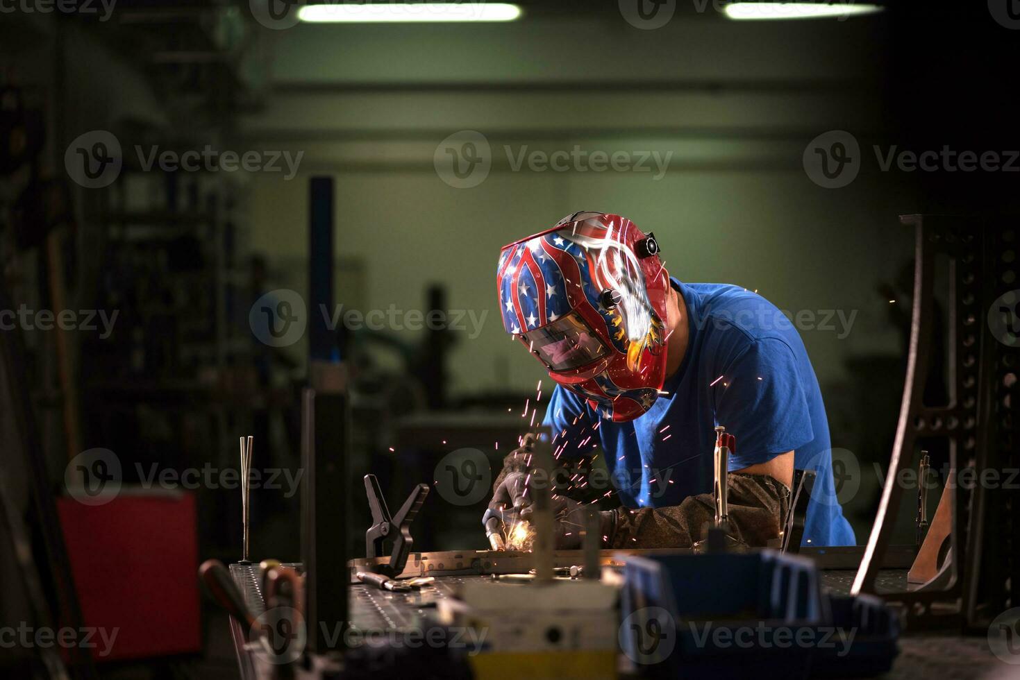 Professional Heavy Industry Welder Working Inside factory, Wears Helmet and Starts Welding. Selective Focus photo