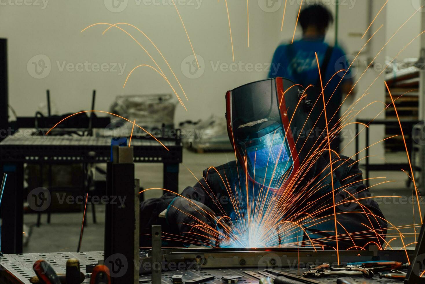 Professional Heavy Industry Welder Working Inside factory, Wears Helmet and Starts Welding. Selective Focus photo