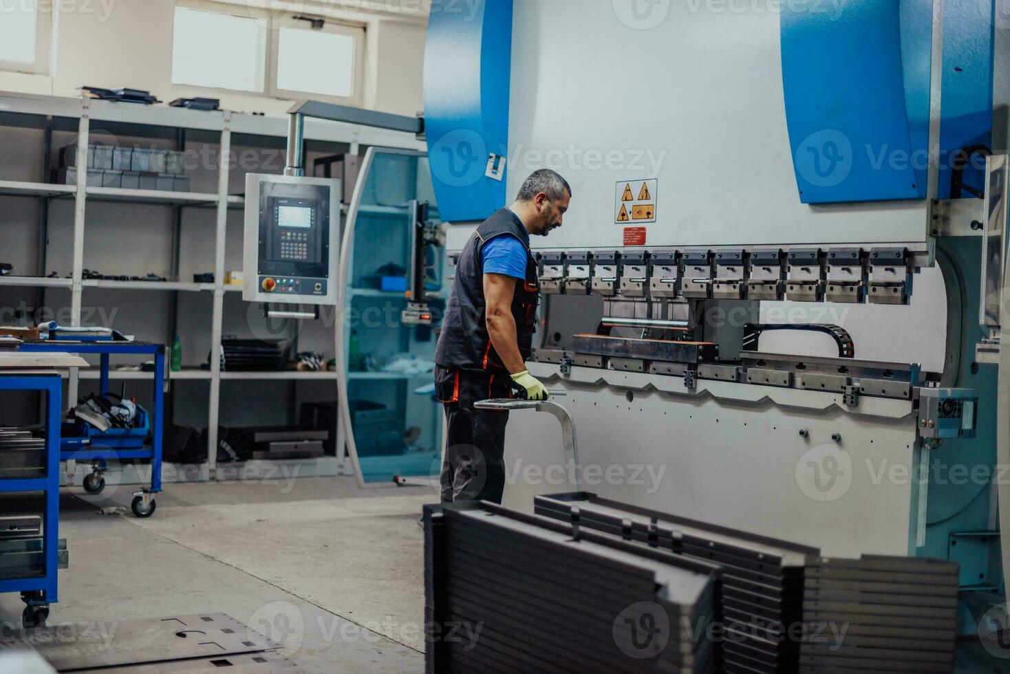 A smart factory worker or engineer makes machines in a production workshop. The concept of industry and engineering. Selective focus photo