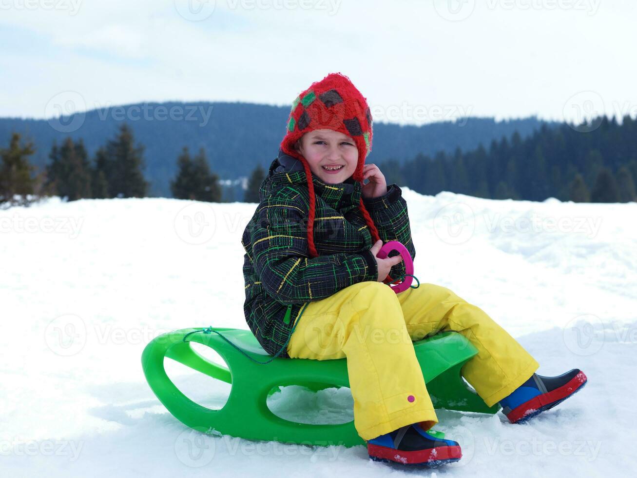 niño feliz divertirse en vacaciones de invierno en nieve fresca foto