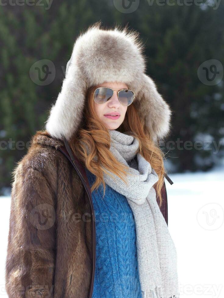 portrait of beautiful young redhair woman in snow scenery photo