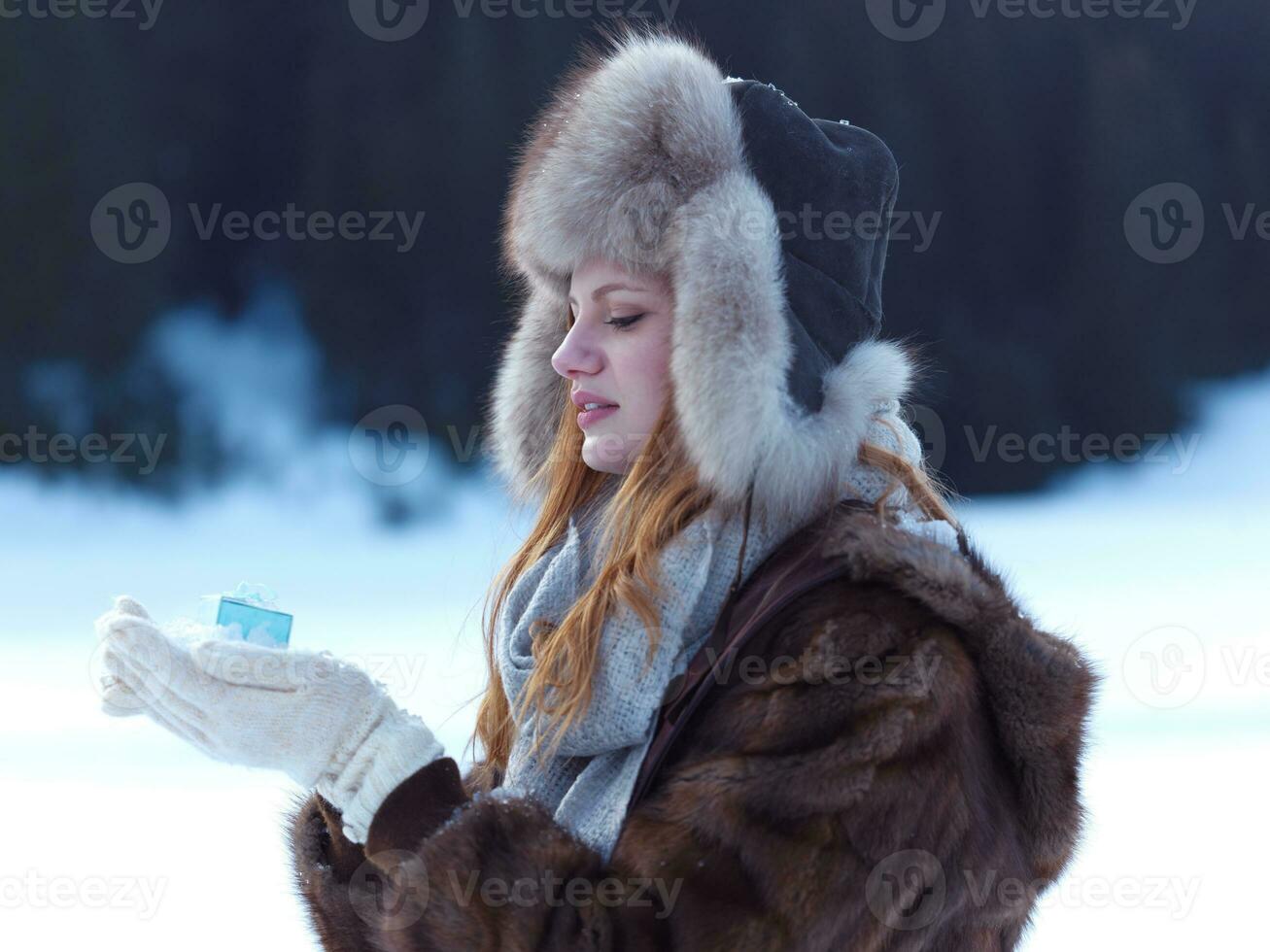 portrait of  girl with gift at winter scene and snow in backgrond photo