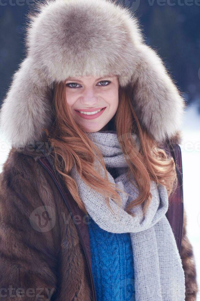 portrait of beautiful young redhair woman in snow scenery photo