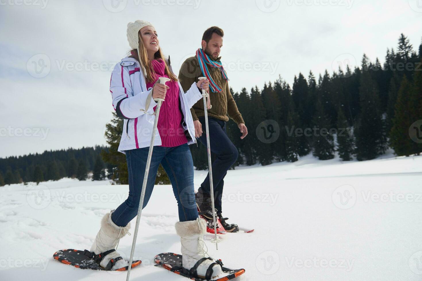 couple having fun and walking in snow shoes photo