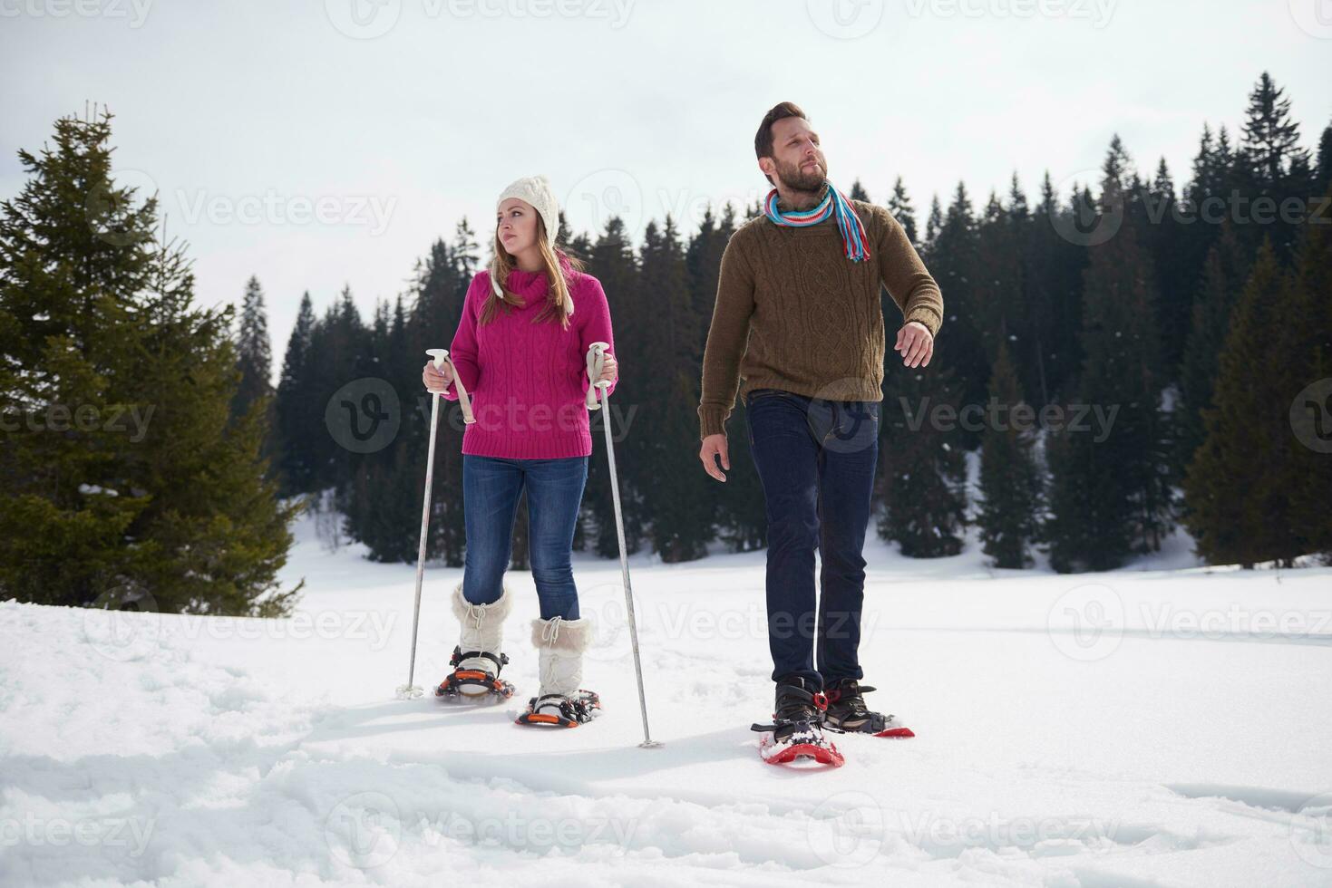 couple having fun and walking in snow shoes photo