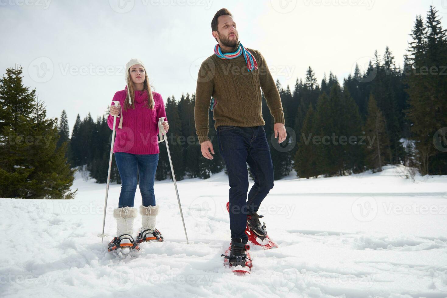 couple having fun and walking in snow shoes photo