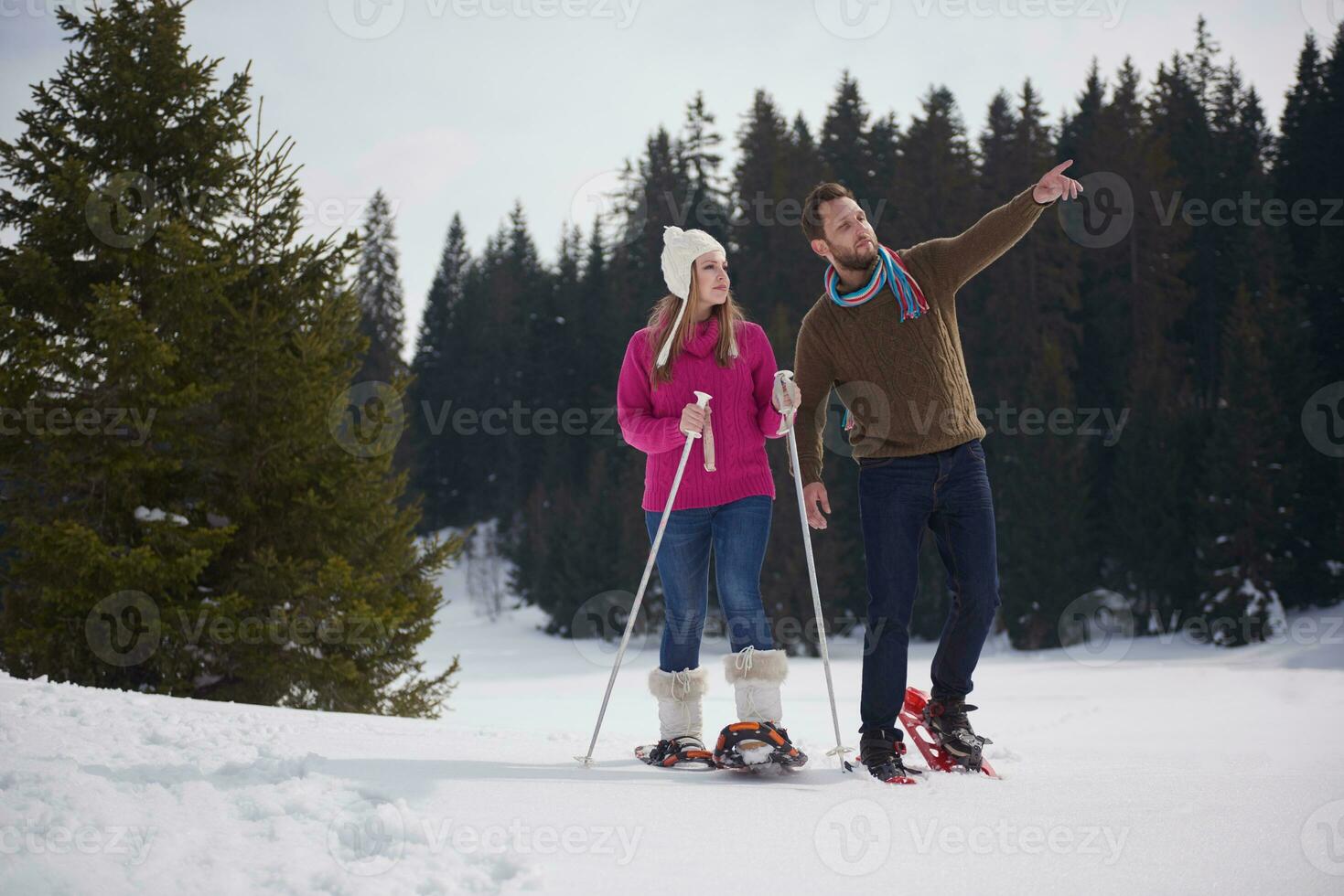 couple having fun and walking in snow shoes photo