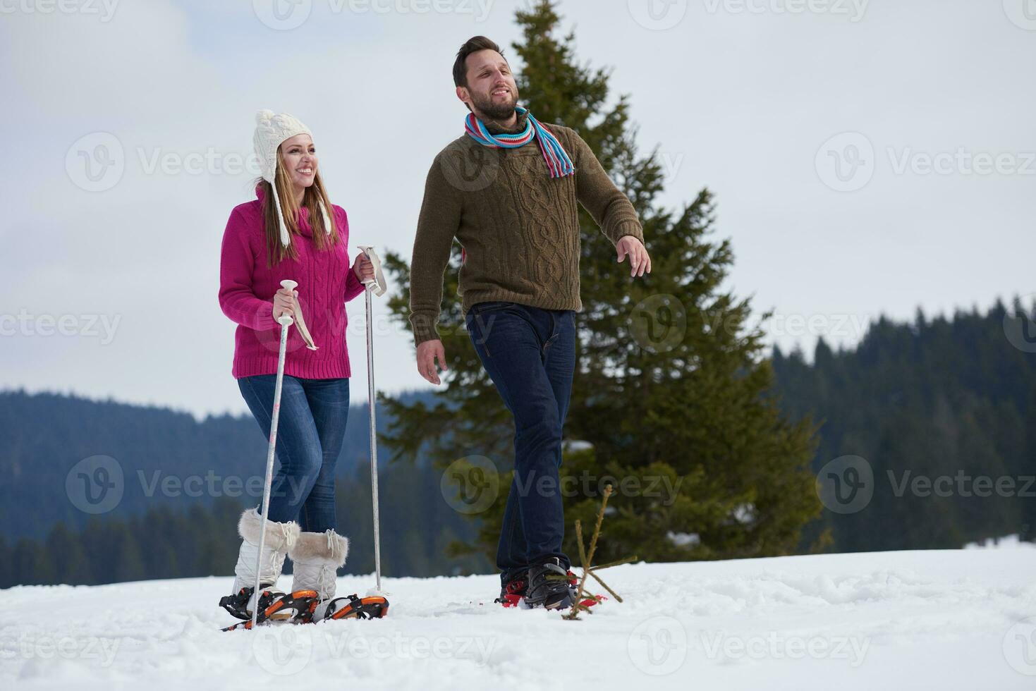 couple having fun and walking in snow shoes photo