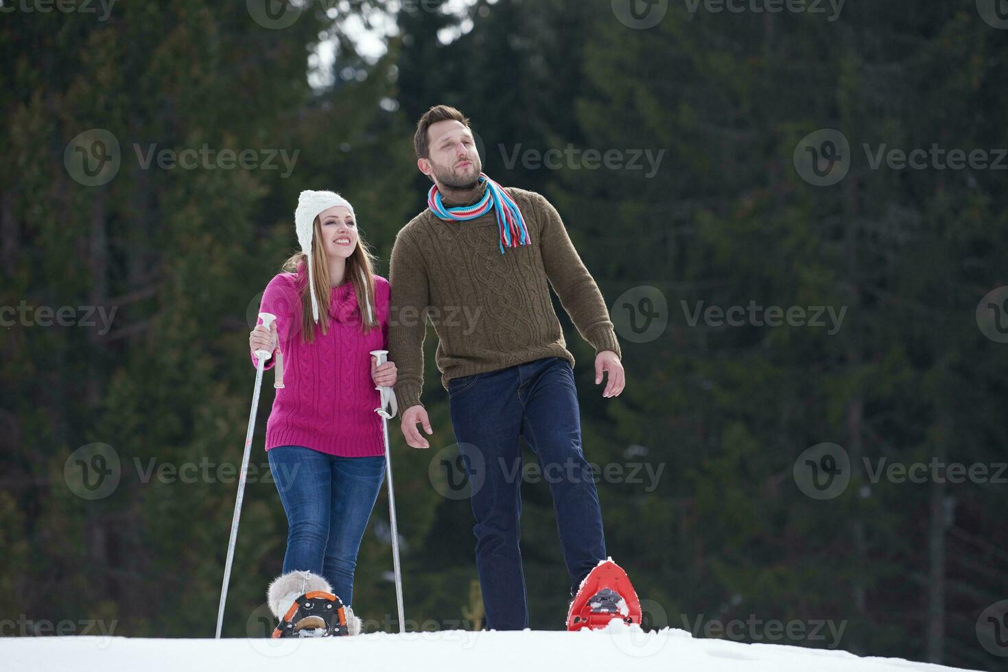 couple having fun and walking in snow shoes photo