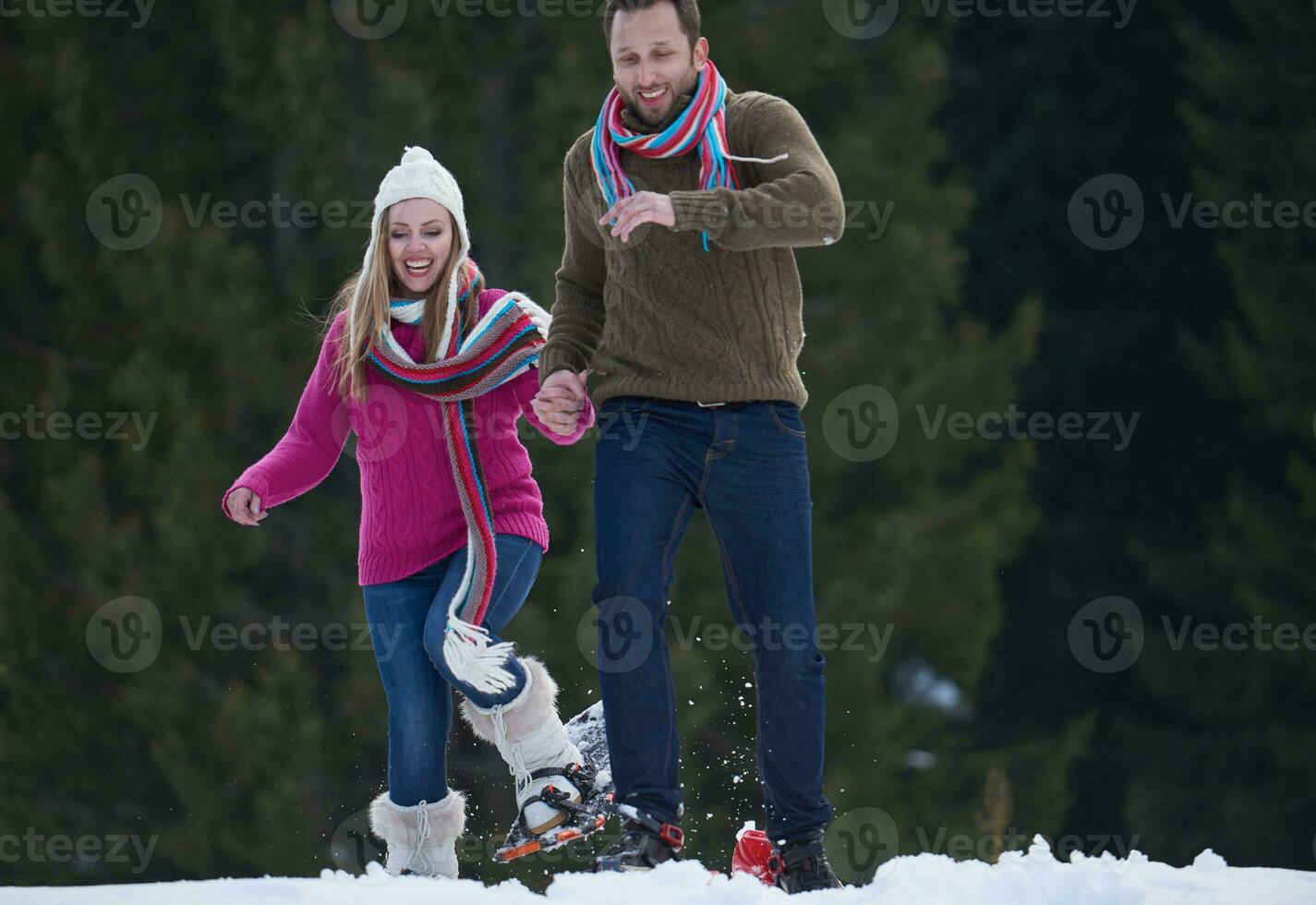 couple having fun and walking in snow shoes photo