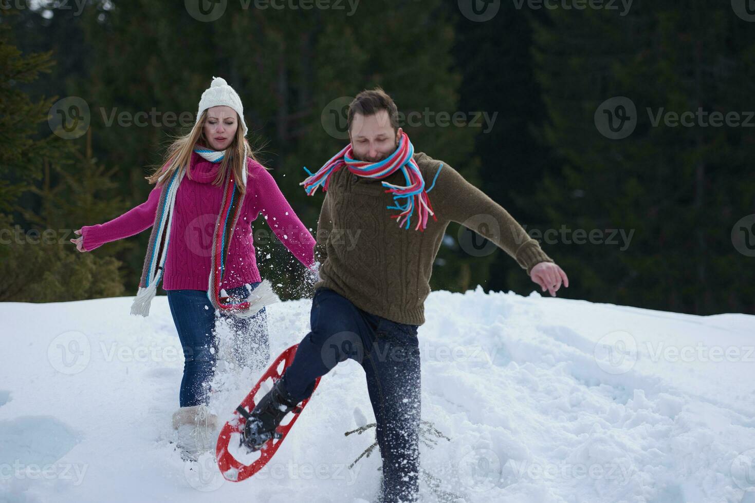 couple having fun and walking in snow shoes photo