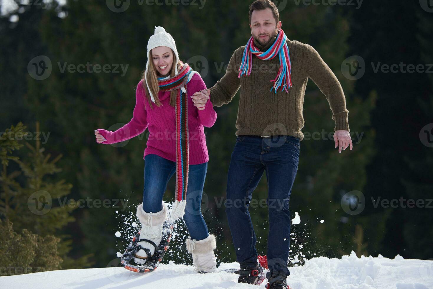 pareja divirtiéndose y caminando con raquetas de nieve foto