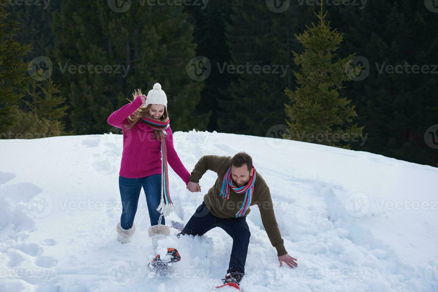 couple having fun and walking in snow shoes photo