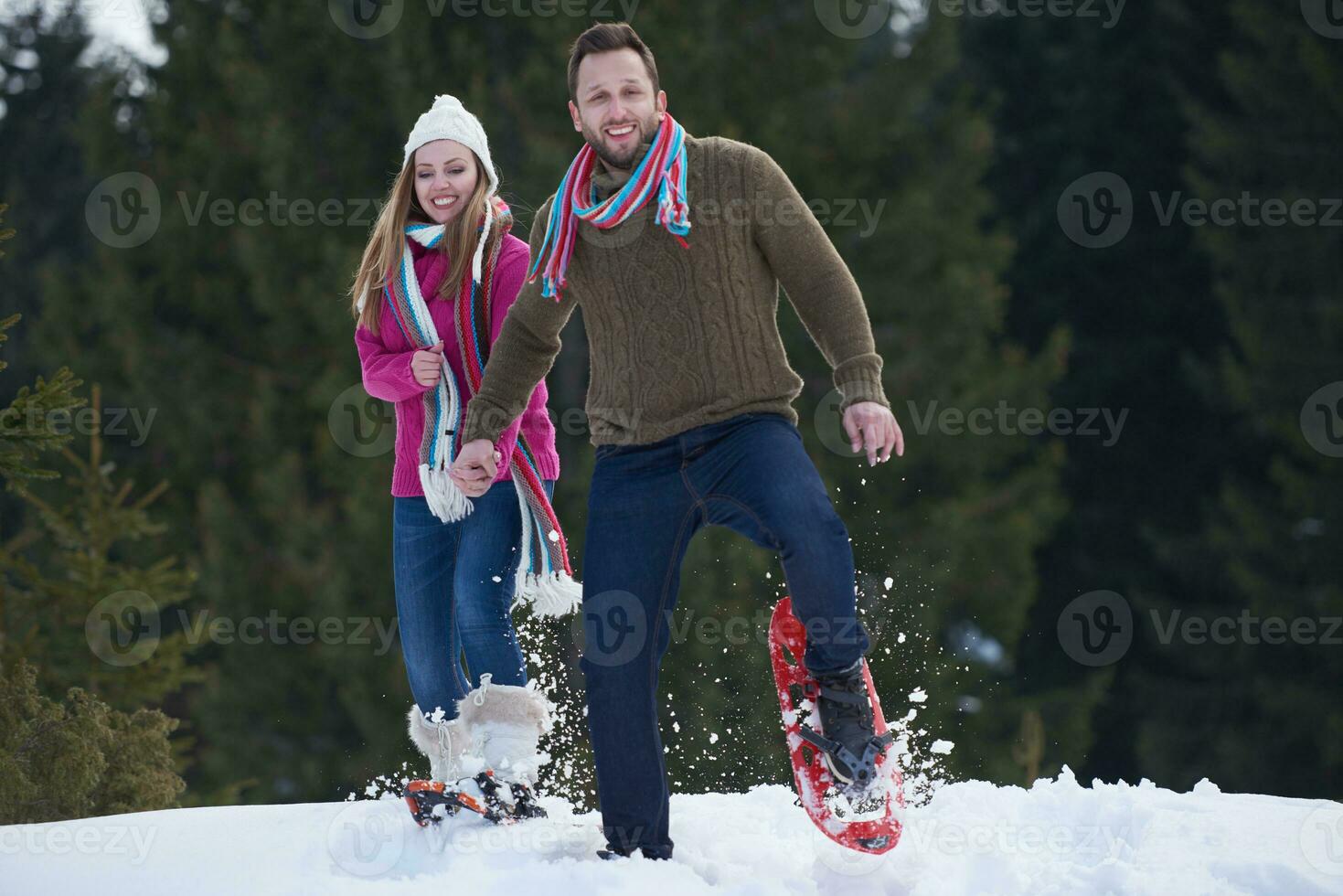 couple having fun and walking in snow shoes photo