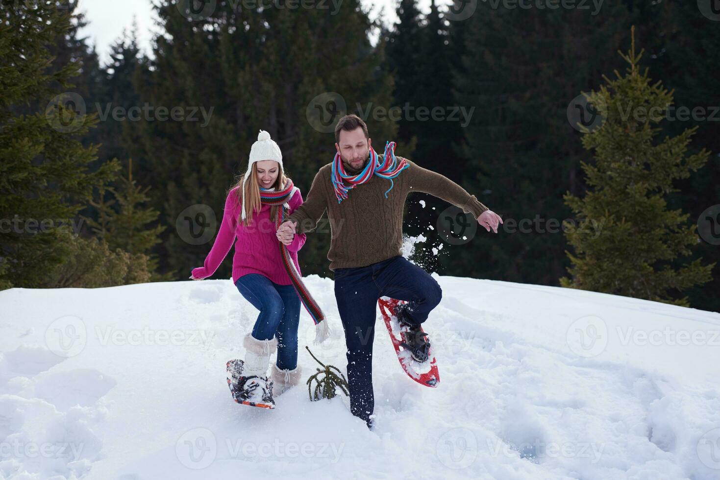 couple having fun and walking in snow shoes photo