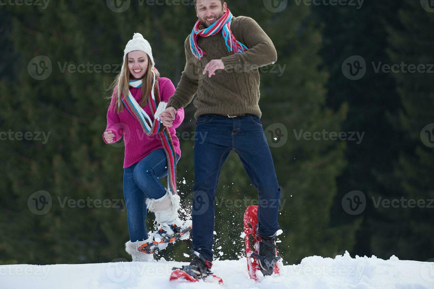 couple having fun and walking in snow shoes photo