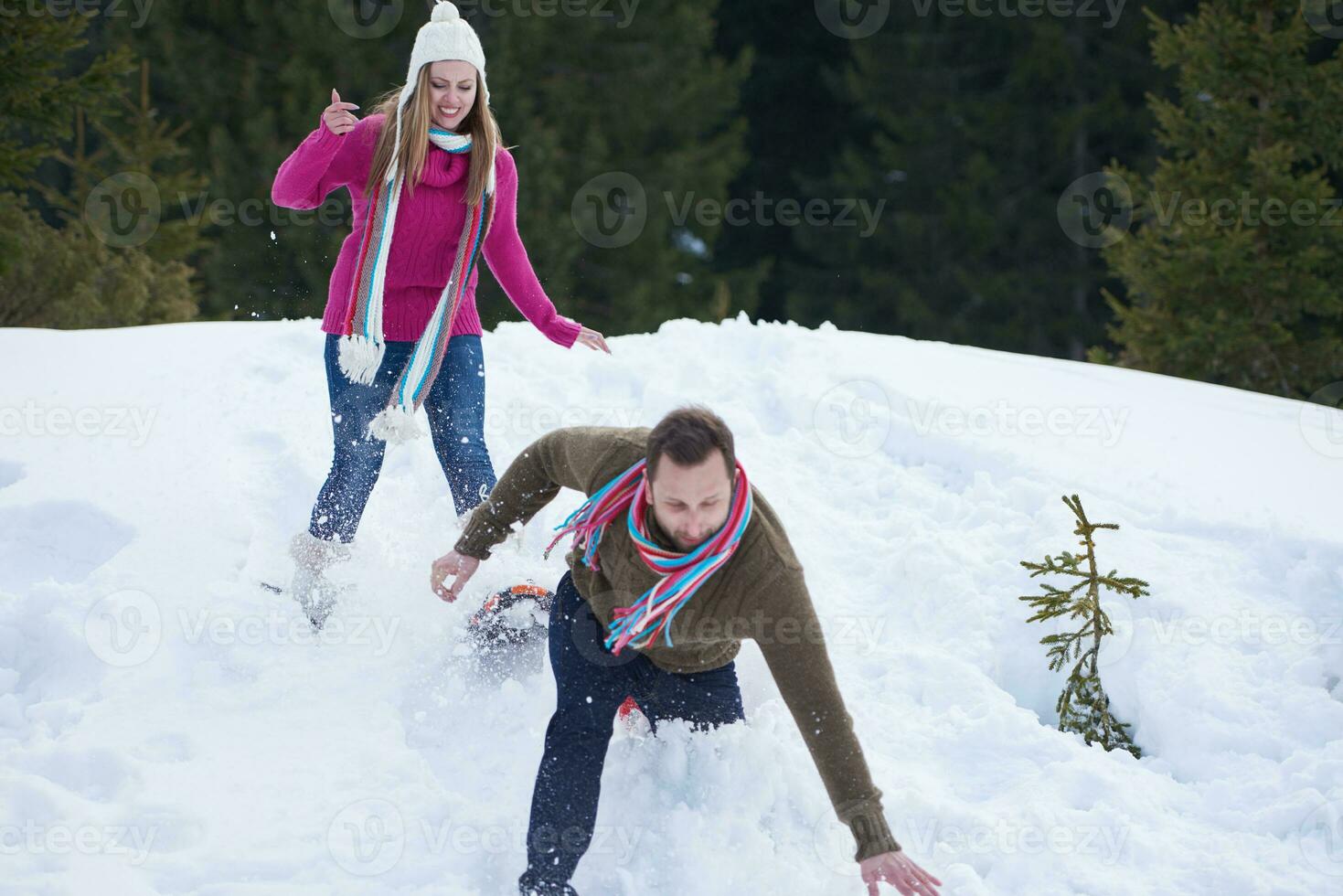 couple having fun and walking in snow shoes photo