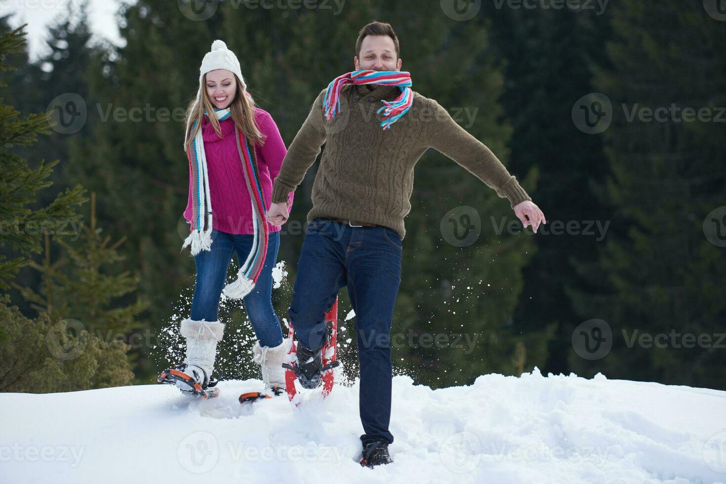 couple having fun and walking in snow shoes photo